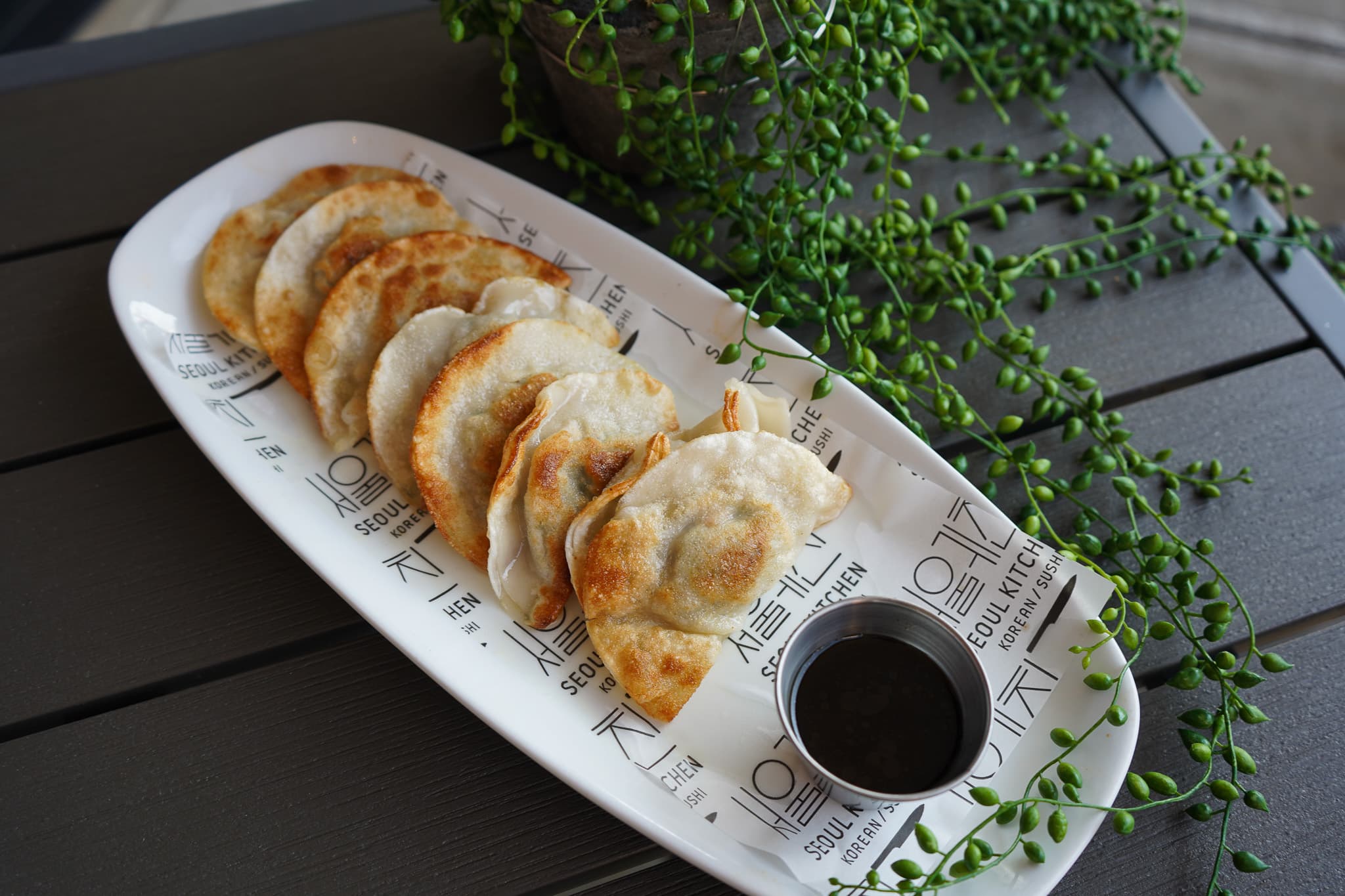 Korean dumplings with dipping sauce on a Seoul Kitchen plate